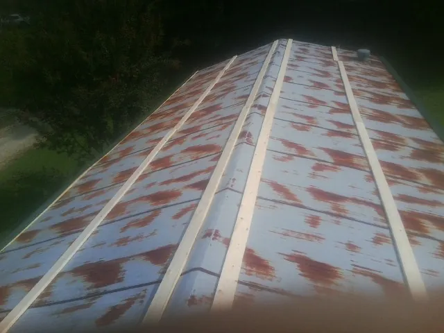 Rusted metal roof panels with new wood purlins before replacement — Storm Damage Roof Repair in Cramerton by Roofing Brothers
