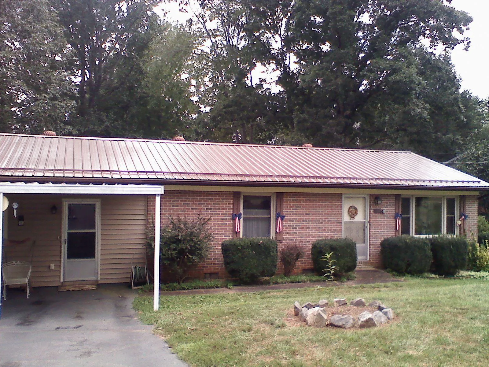 Bronze metal roof and carport on a brick ranch home — Roof Repair work by our crew in Cramerton